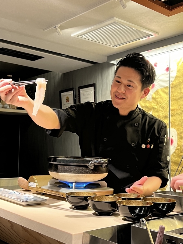 ふぐのしゃぶしゃぶしゃぶのプレゼンテーションをする様子