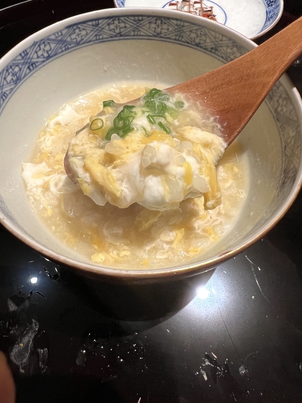 ふぐの雑炊を器からスプーンですくう画像