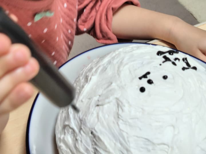 ケーキにチョコペンでデコレーションしている様子