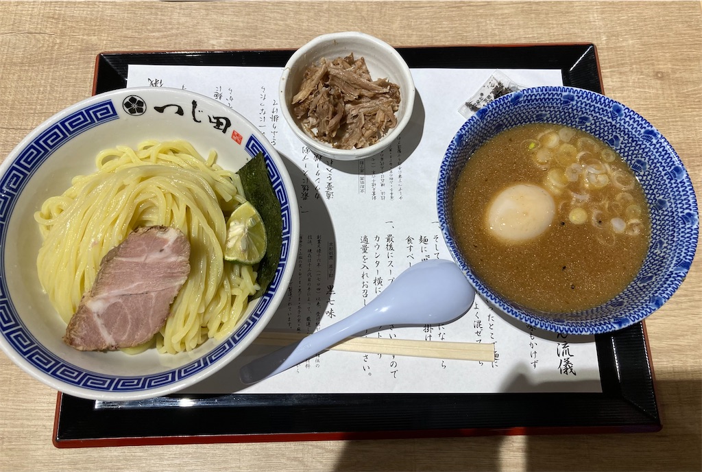 「つじ田」のつけ麺の一杯。チャーシューのスライスとすだちが添えられたつややかな麺が盛られている。