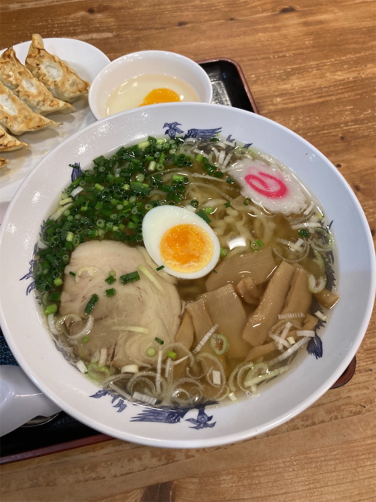 佐野ラーメン。ラーメンにはネギ、チャーシュー、半熟卵、なると、メンマがトッピング