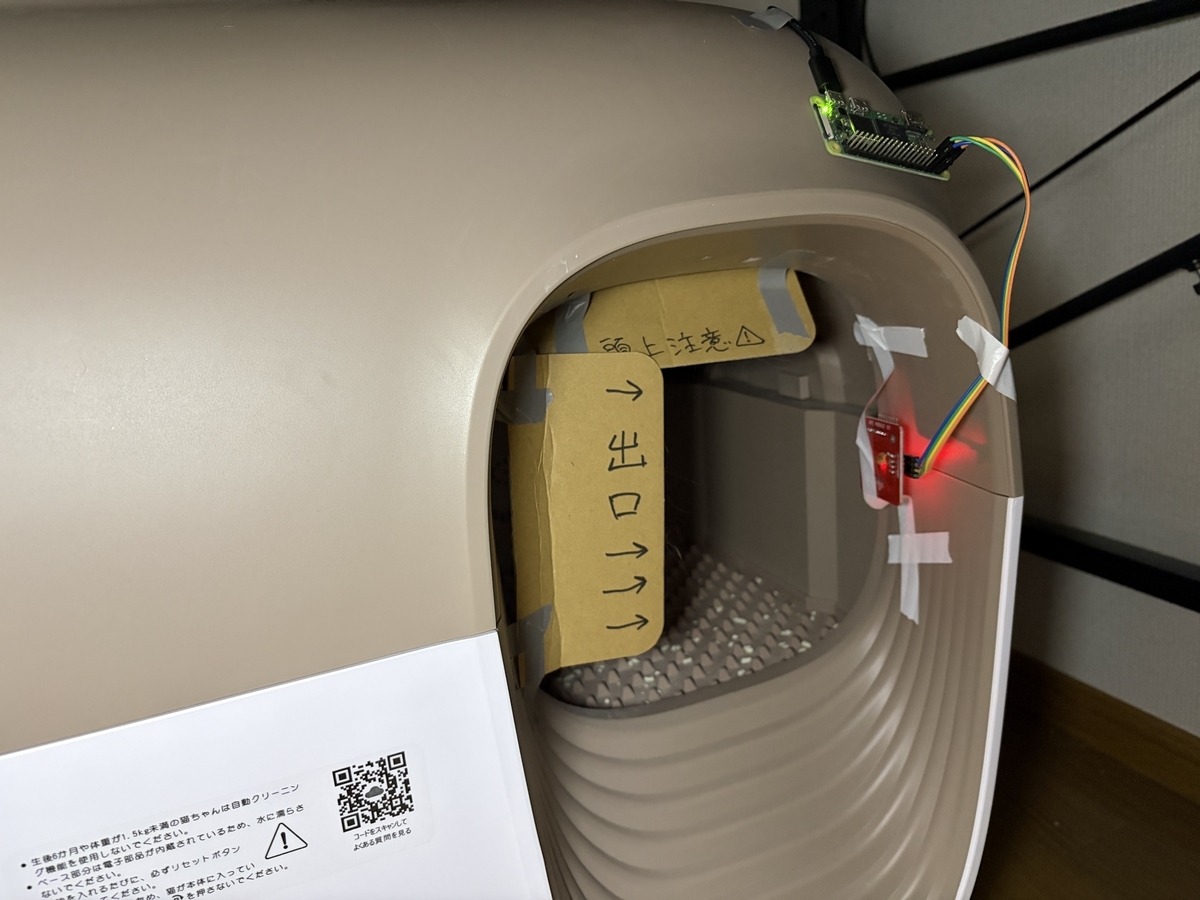 自動トイレ出入り口のサイズを段ボールを貼り付けて制限している様子