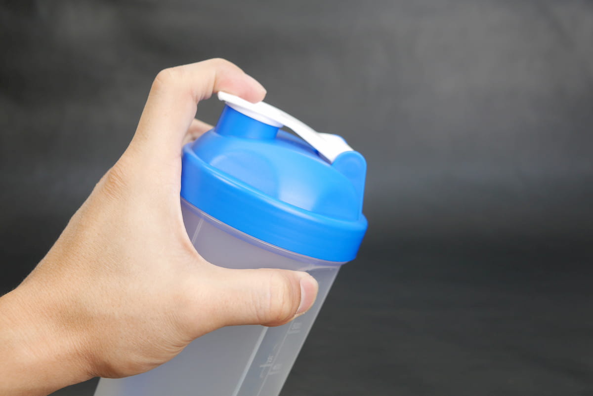 キャップを指で押さえながらシェイク