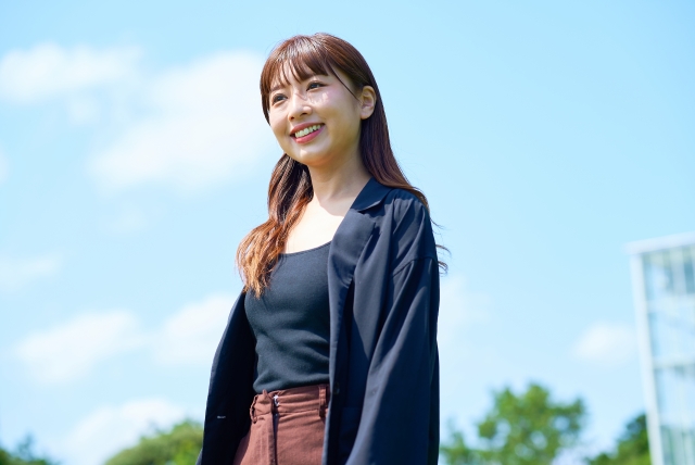 屋外でリラックスした表情を見せる若い女性