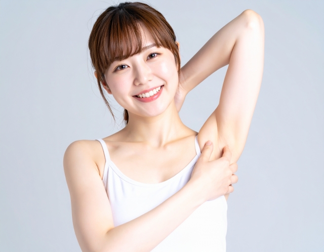 脱毛を完了してスッキリしたワキをチェックしている女性