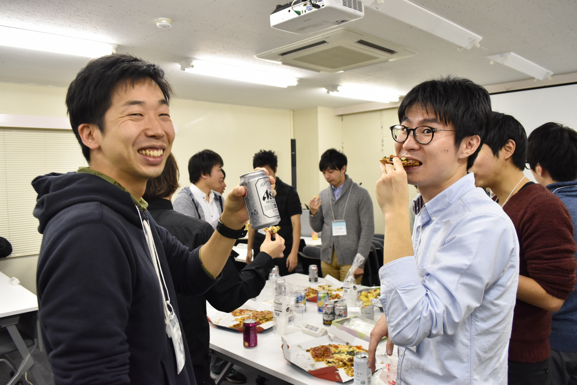 懇親会でビールとピザを囲んでの一コマ