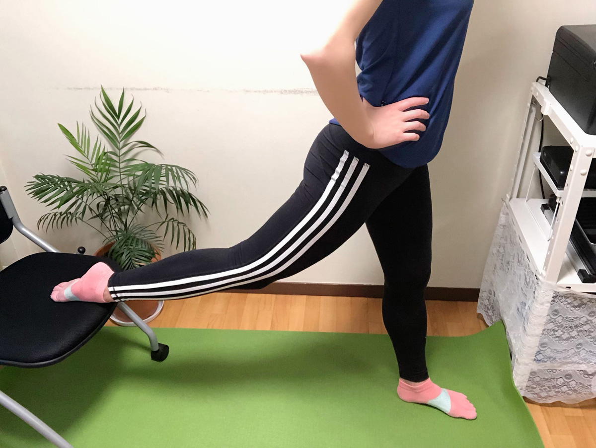 ブルガリアンスクワット1。イスの前方にたち、片脚の甲を後ろのイスにのせる