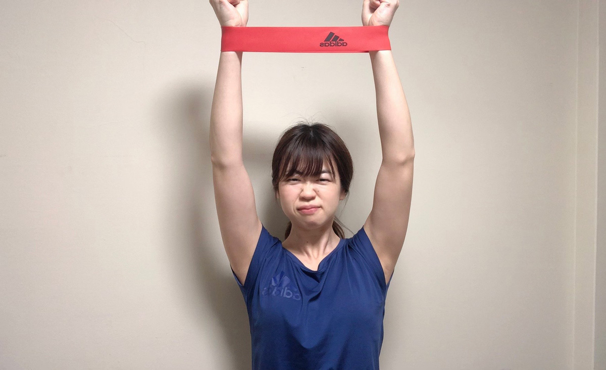 バンドをピンと張りながら両腕を頭の真上に伸ばす