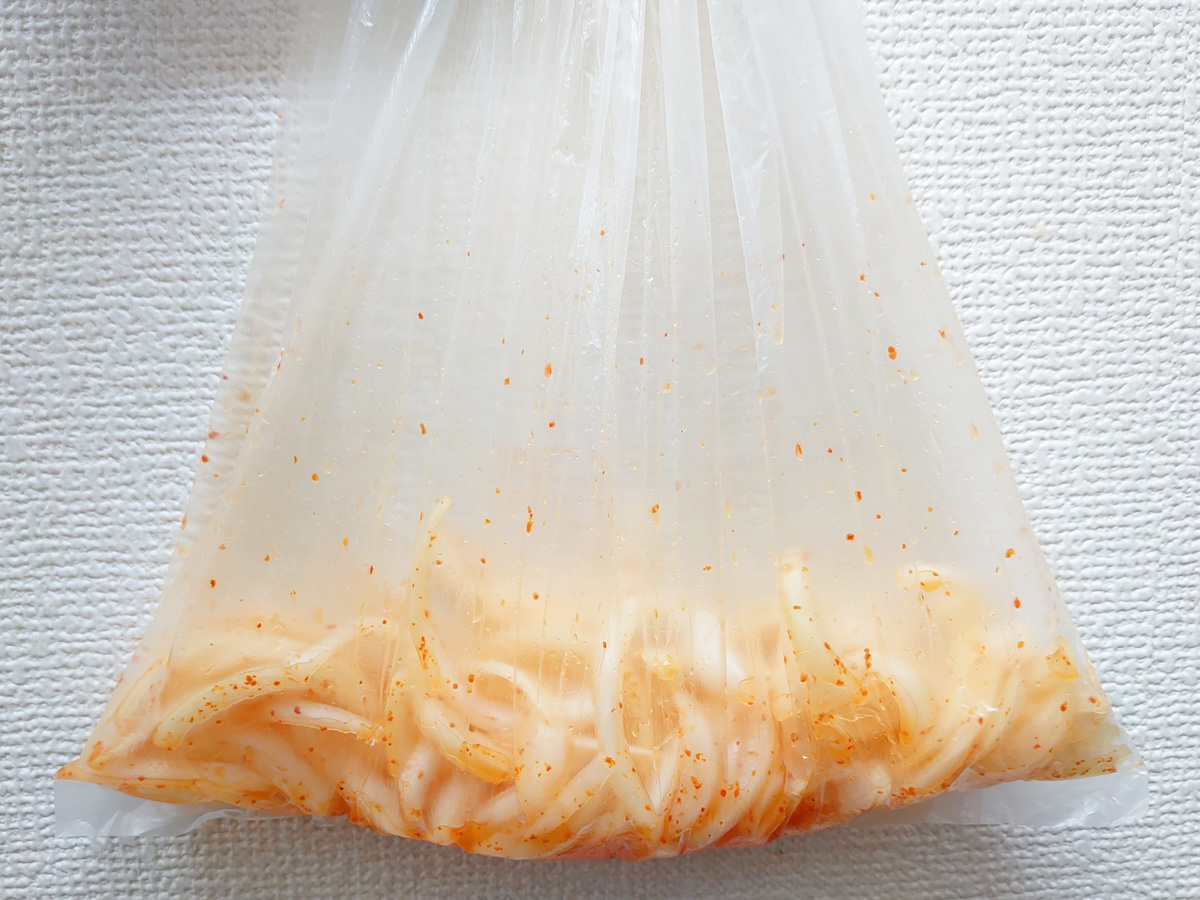 玉ねぎアチャールの作り方。材料を全てビニール袋などに入れ、混ぜ合わせるようにもみ込みます