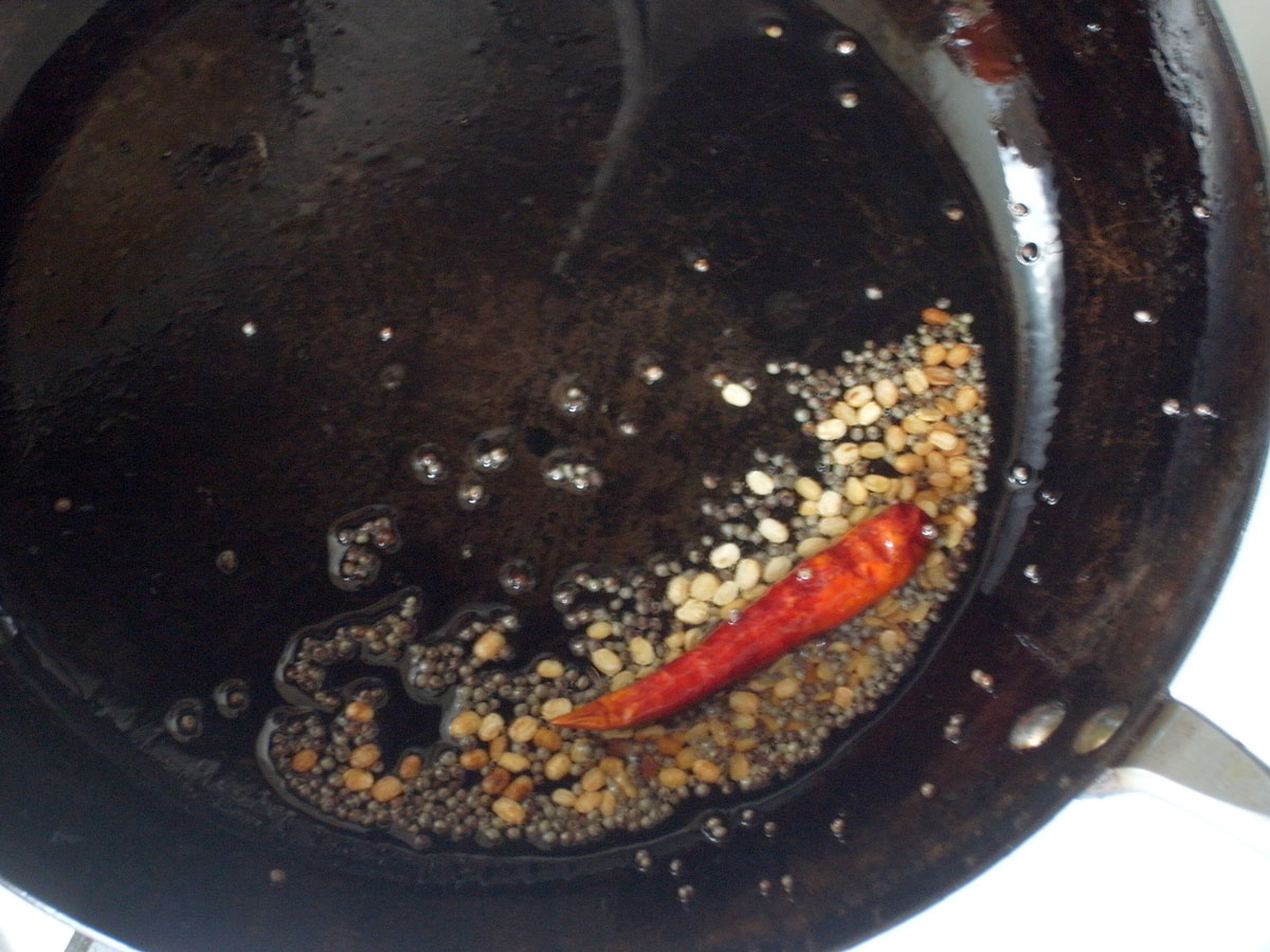 フライパンに油、ブラウンマスタードシード、ウラドダルを入れて中火にかけ、ウラドダルがきつね色になりブラウンマスタードシードがパチパチと弾けるまで混ぜながら加熱する。