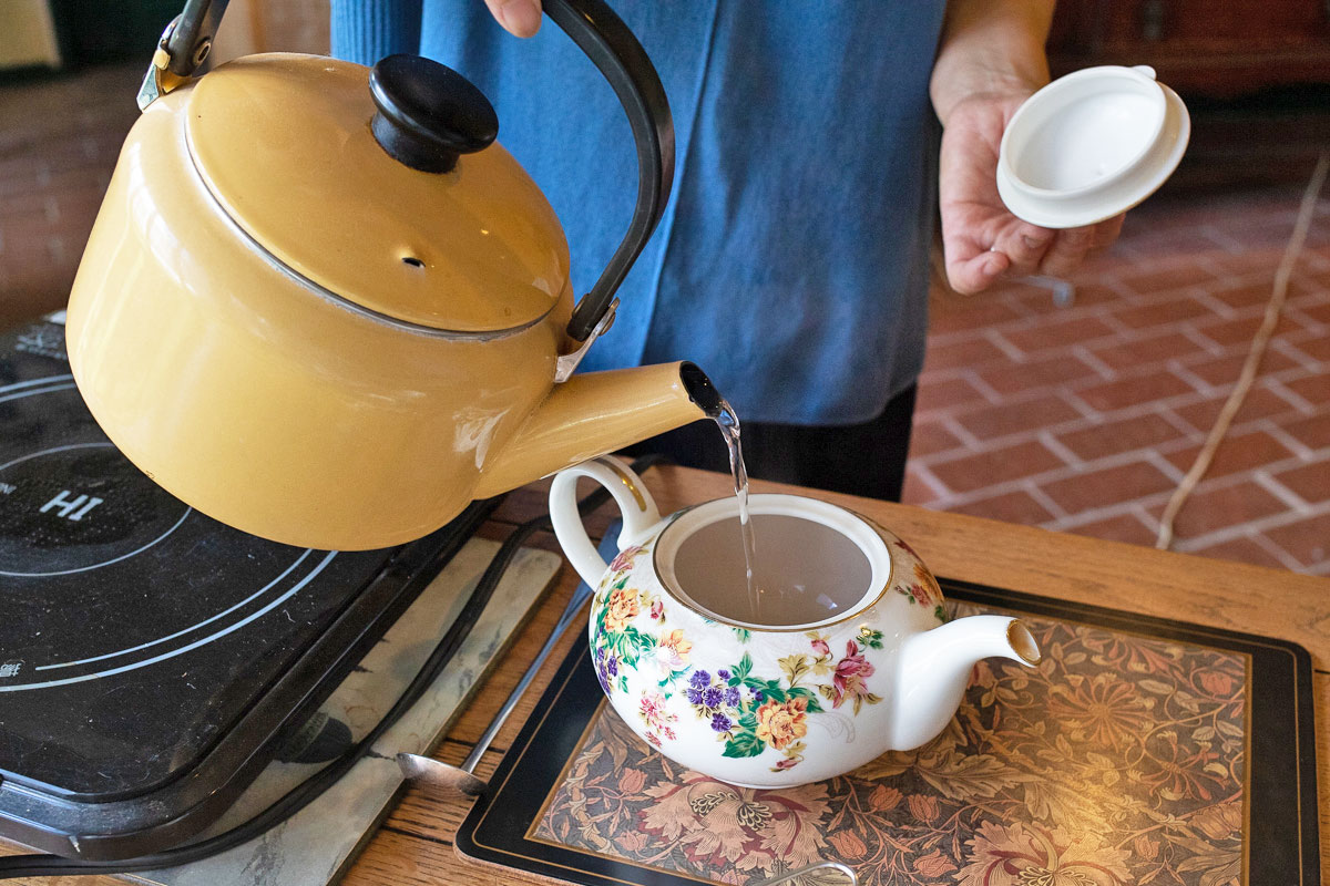 ホットミルクティーの入れ方。ポットとカップに湯(分量外)を注ぎ、しっかり温める。