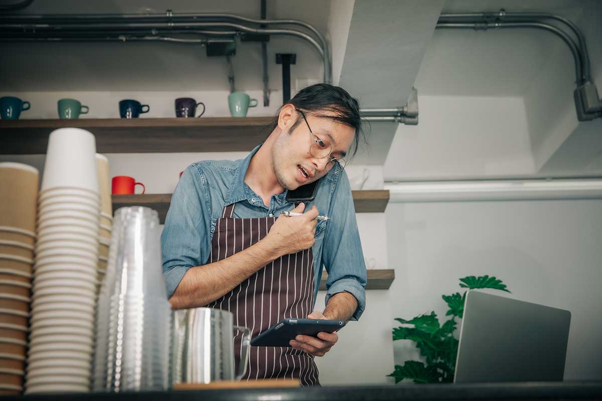 予約の電話を受けている飲食店の店員の写真