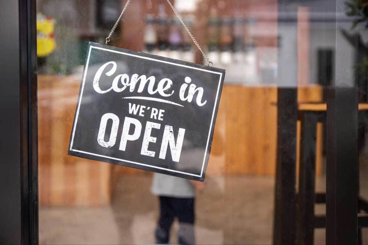 お店のドアに掲げられた「OPEN」の看板の写真