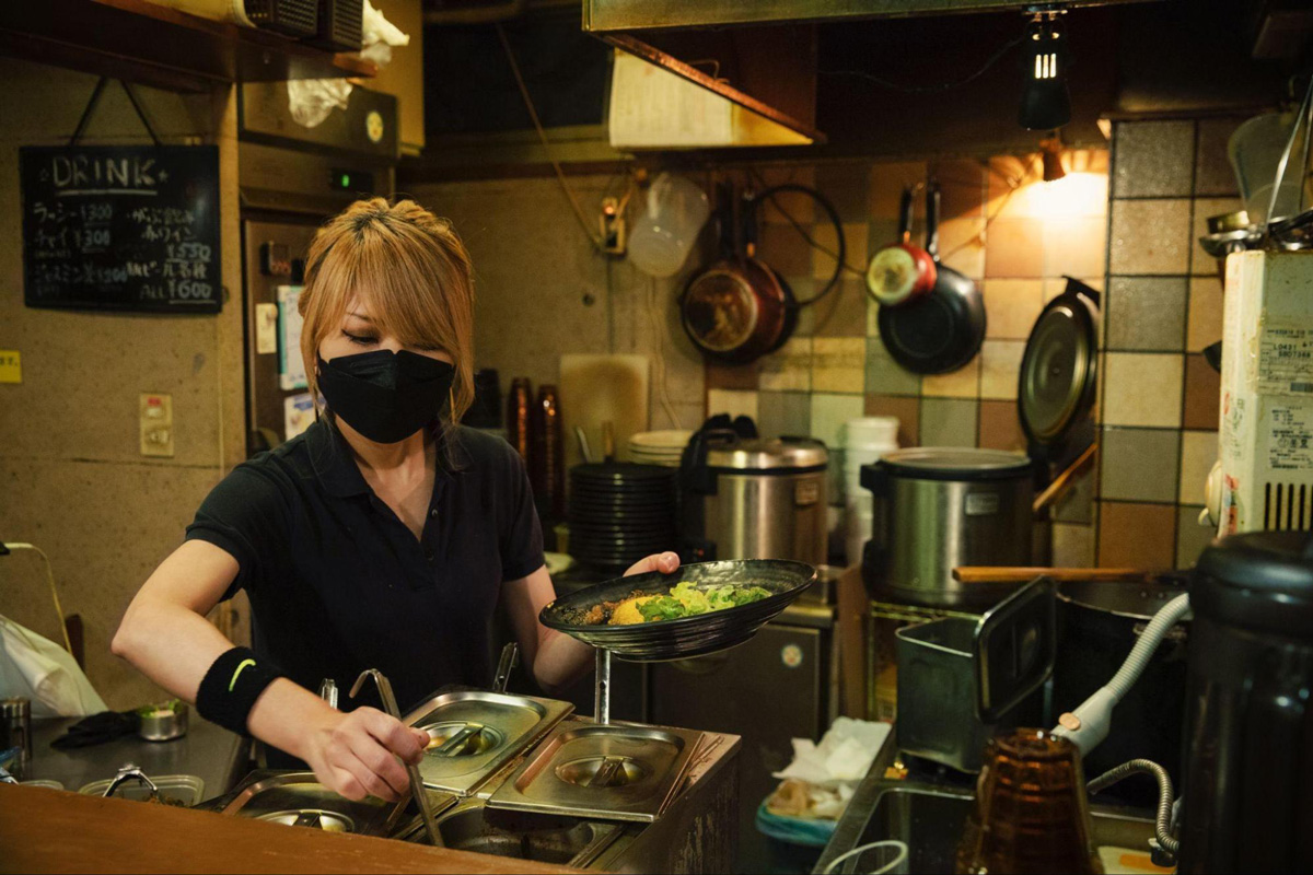 SPICY CURRY 魯珈の店長、齋藤絵理さんが店内でカレーを調理している様子