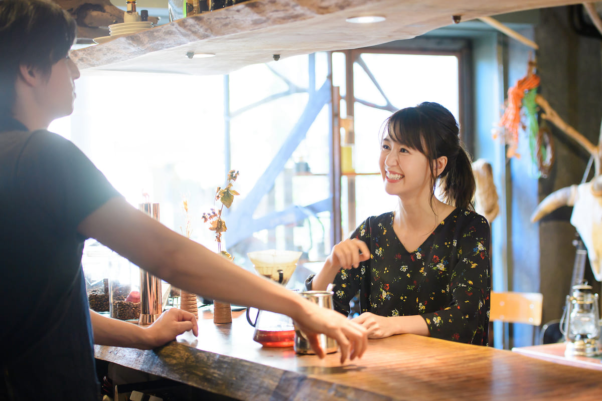 飲食店で店員と話す女性