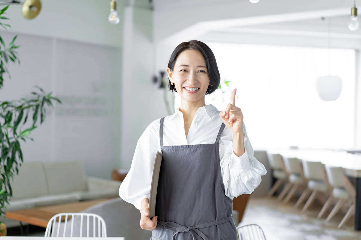 人差し指を立てているカフェの店員