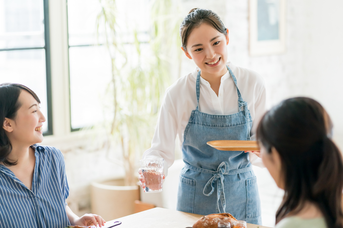 お客さんにお水を渡す女性スタッフ