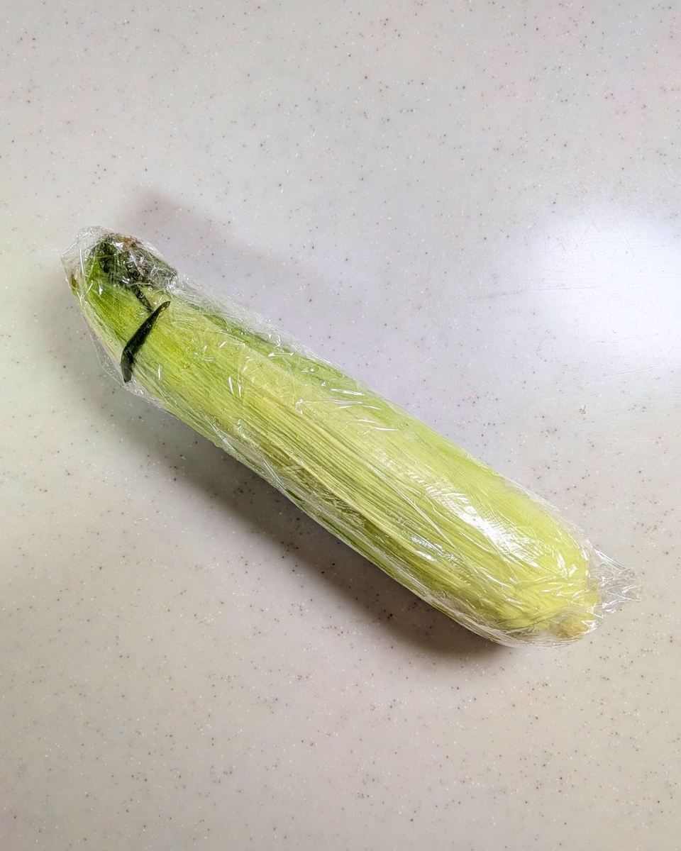 とうもろこしをラップで包み電子レンジ加熱する工程