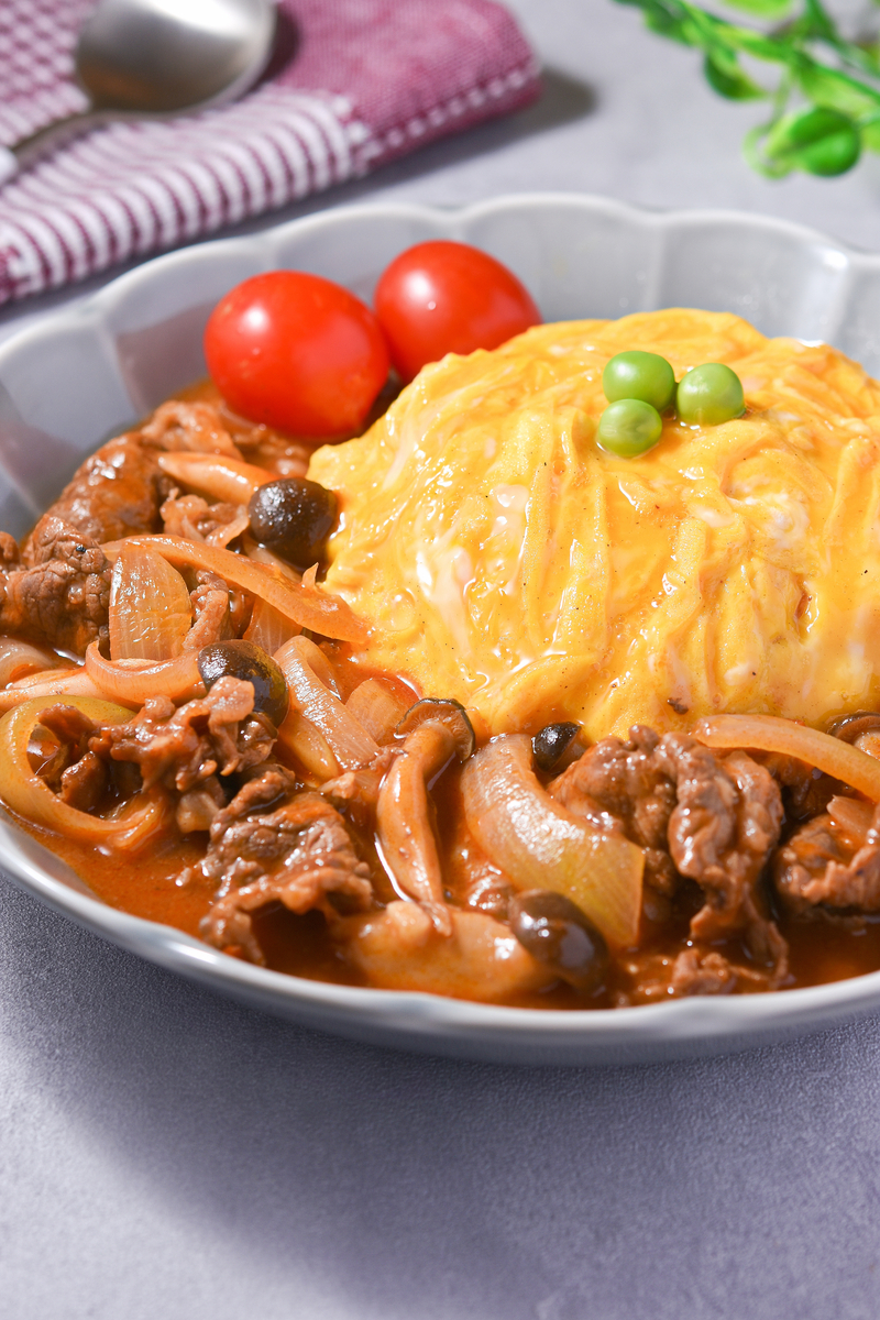 オムハヤシの完成写真。ふわとろ卵とコクのある手作りソースがかかった洋食ごはんの寄りの画像