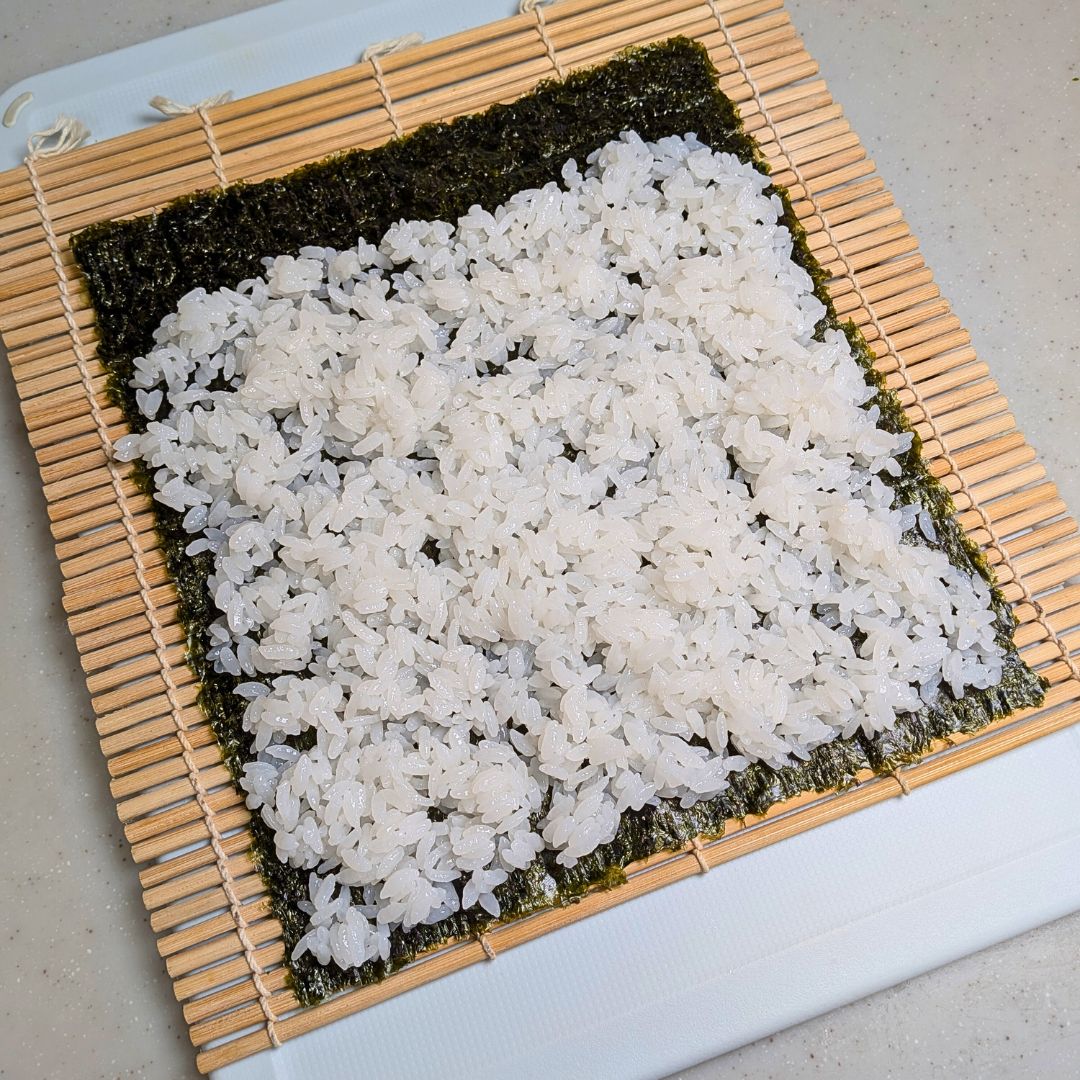 味を付けたご飯を海苔に広げる工程