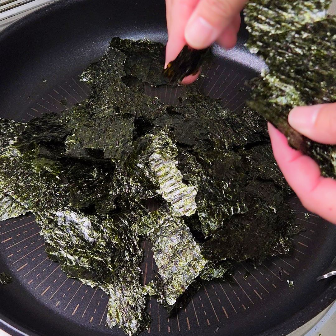 フライパンに海苔をちぎって入れる工程