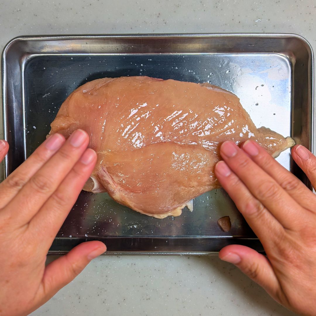 肉に砂糖と塩を丁寧に擦り込んでいる様子