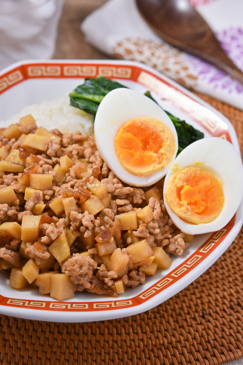 ご飯の上に筍そぼろと卵を盛り付ける美味しそうな魯肉飯の完成