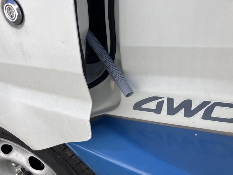 助手席のドアの隙間から車外へ垂らした排水パイプ