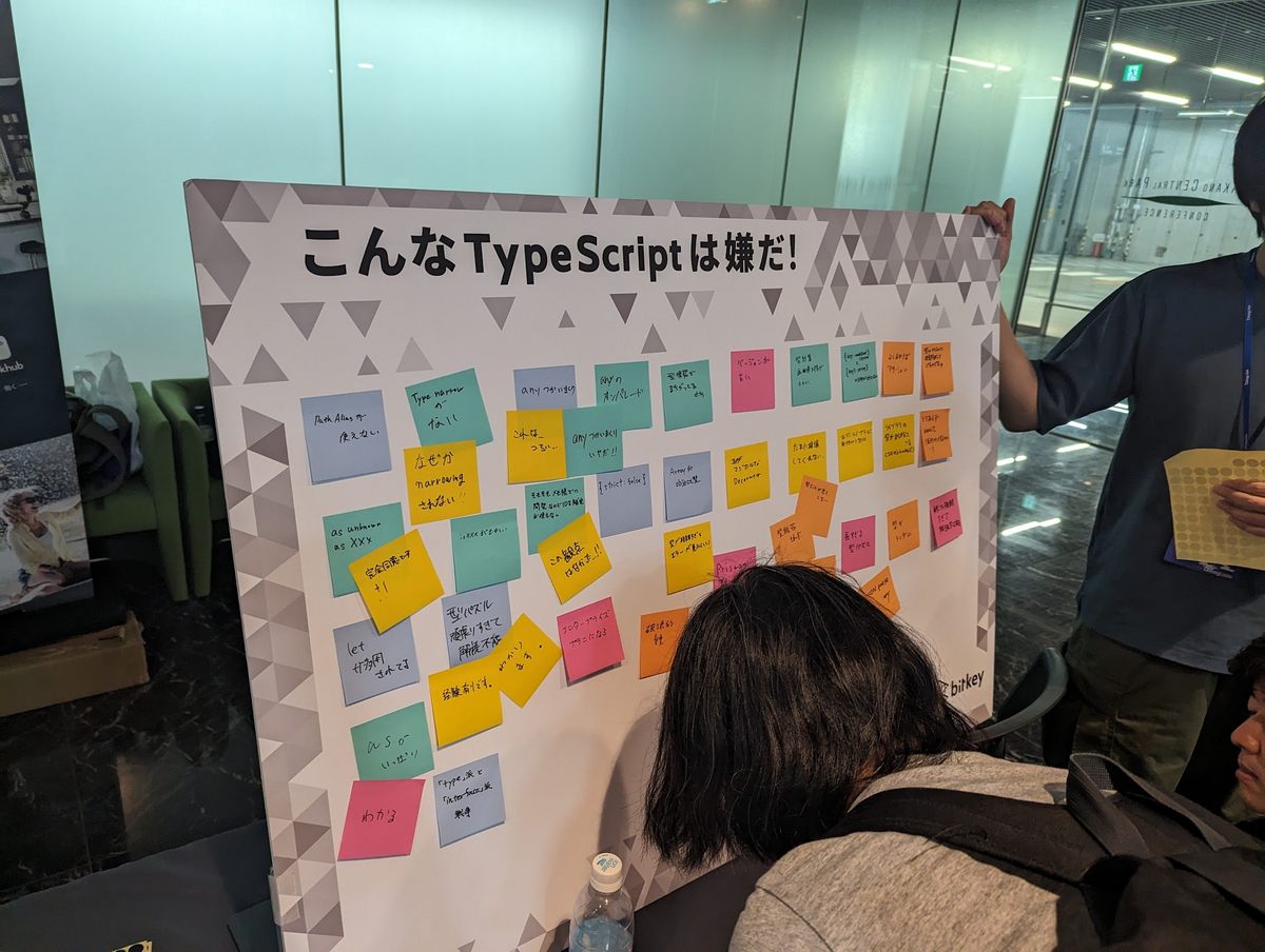 株式会社ビットキーのスポンサーブースの光景。「こんなTypeScriptは嫌だ！」というボードが設置してありポストイットで各々が思う嫌なTypeScriptのことが貼り付けられている