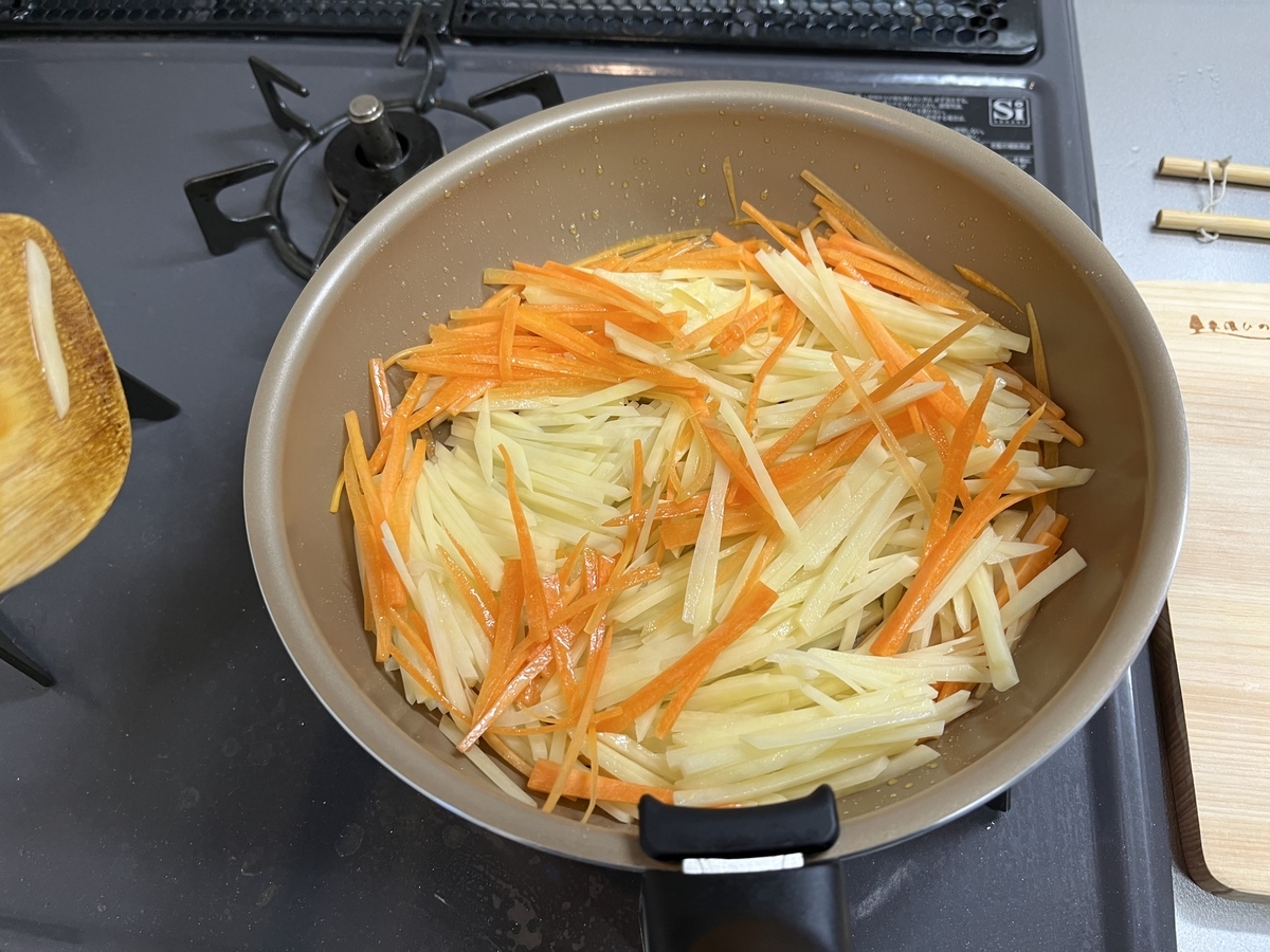 フライパンでじゃがいもと人参を炒める