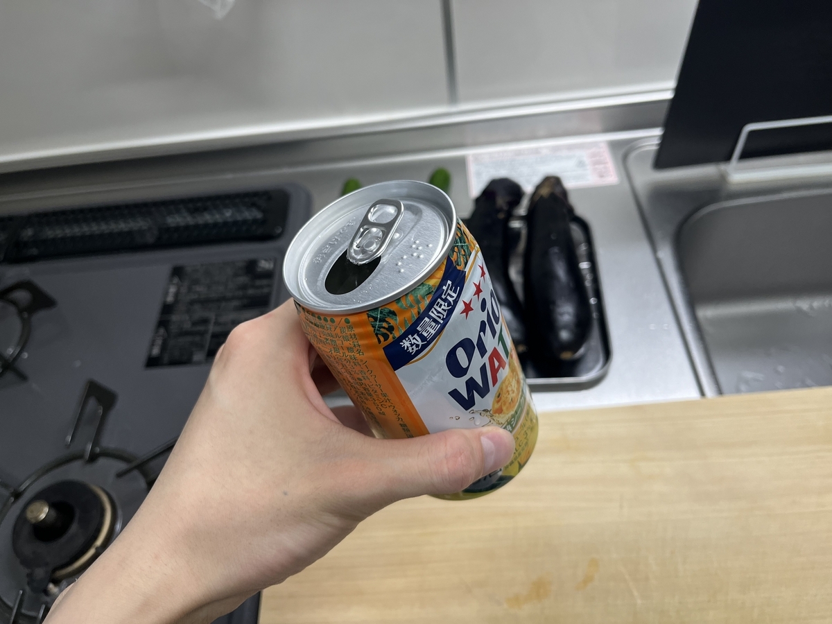 缶のフタを開けたチューハイを手に持っている