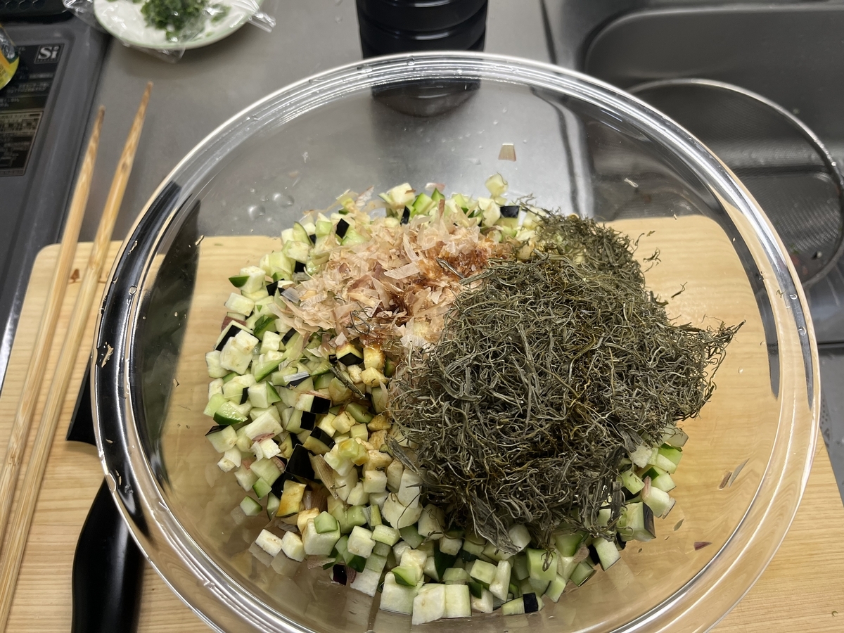 ボウルに、きゅうり、なす、みょうが、かつお節、がごめ昆布を入れている様子