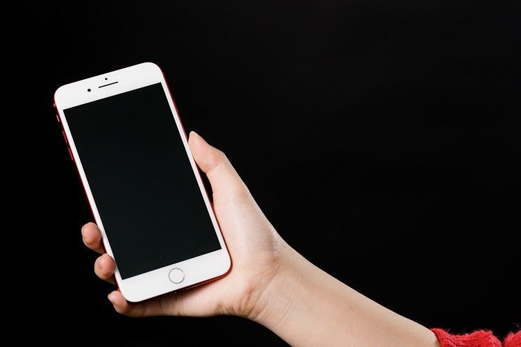暗い部屋でスマホを手に取っている様子