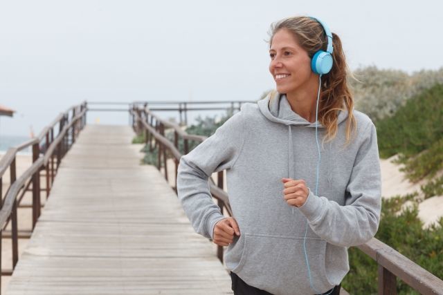 ヘッドホンで音楽を聴きながらランニングする女性