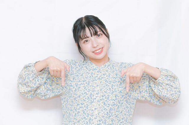 両指を下に指した女性