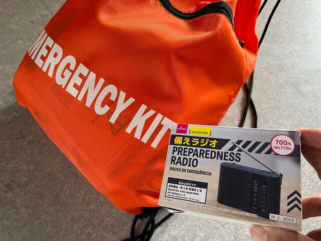 100均のダイソーで売っている防災グッズ備えラジオを防災バッグに入れるところ