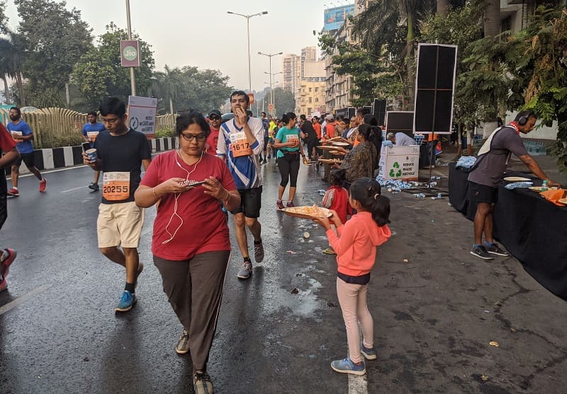 ムンバイマラソンでオレンジを配る少女