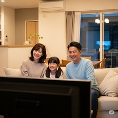 両親と長女でアニメ映画を観ている画像