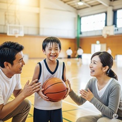 両親にバスケットボールを褒められて喜んでいる男の子の画像