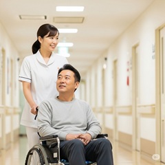 患者さんの車いすを押す看護師