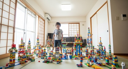 ブロック作品が並ぶ部屋で遊ぶ子ども、おもちゃ選びが育む才能