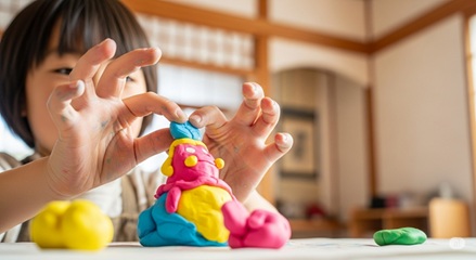 2～3歳児が粘土遊びで指先の巧緻性と想像力を育む。五感を刺激する感覚統合遊びの例。