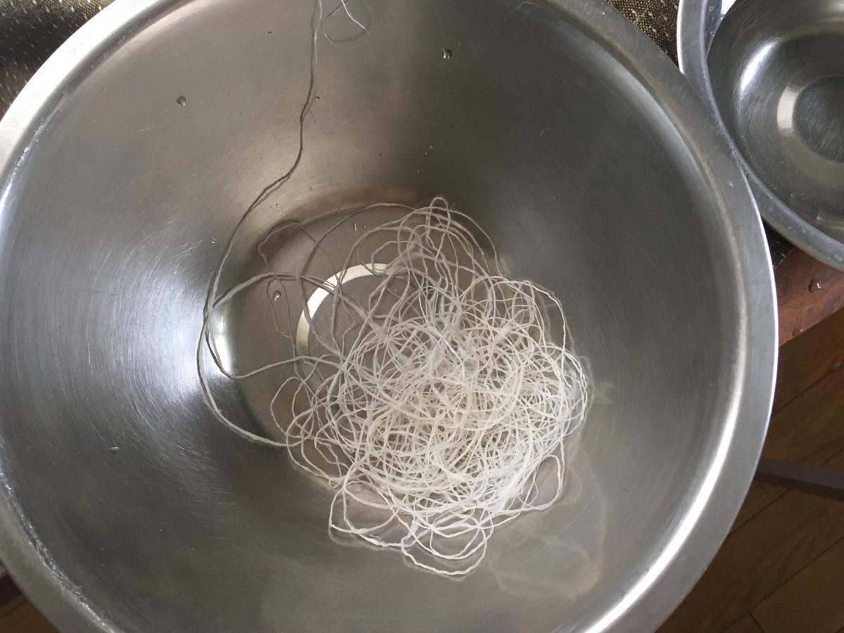 撚った糸はからの容器に入れていく