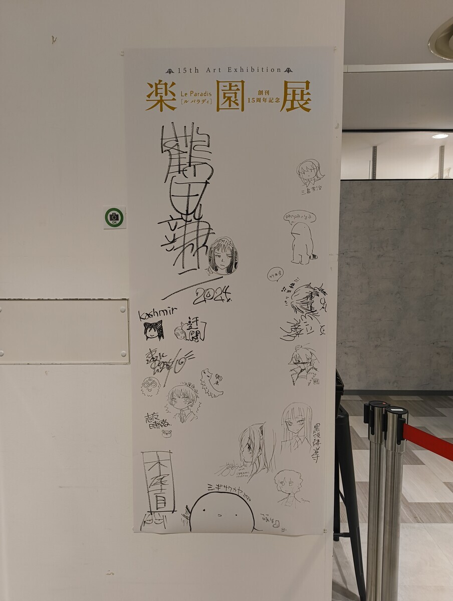 漫画雑誌『楽園』の展示イベント「楽園展」に展示された、連載陣のサインが描かれたパネルの写真