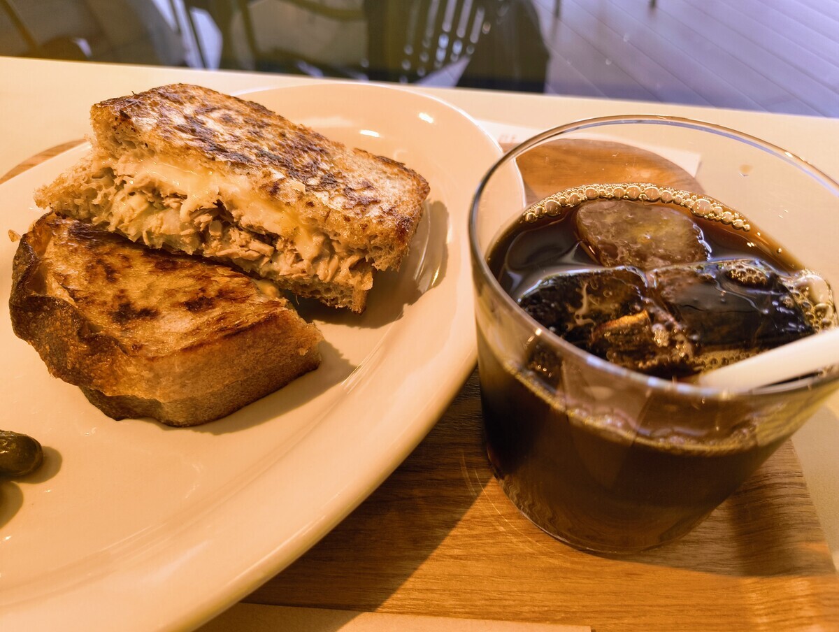 ツナメルトのホットサンドとアイスコーヒーの写真