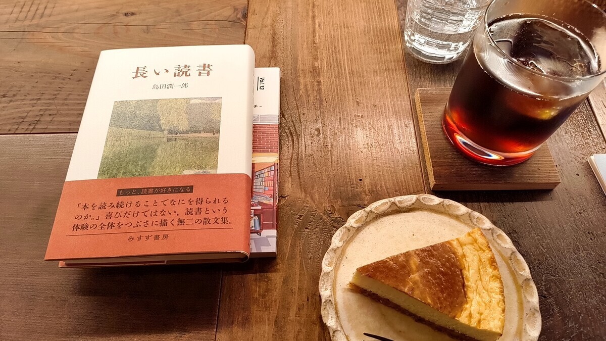 fuzkueの店内で机上を撮った写真。島田潤一郎の『長い読書』という書籍と、アイスコーヒー、チーズケーキが並んでいる。