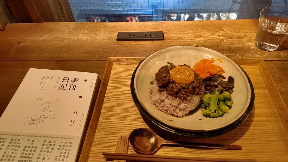 fuzkueの店内で机上を撮った写真。『季刊日記』という雑誌とカレーが並んでいる。