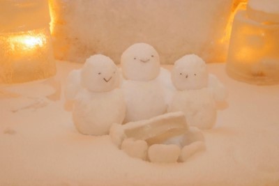 淡いライトに照らされた３つの小さい雪だるま