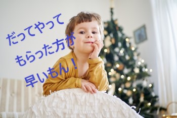 大きな白いクッションに頬杖ついて笑う男の子とクリスマスツリー