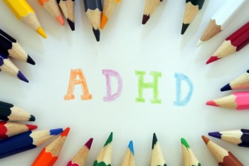 たくさんの色鉛筆に囲まれた「ADHD」という文字